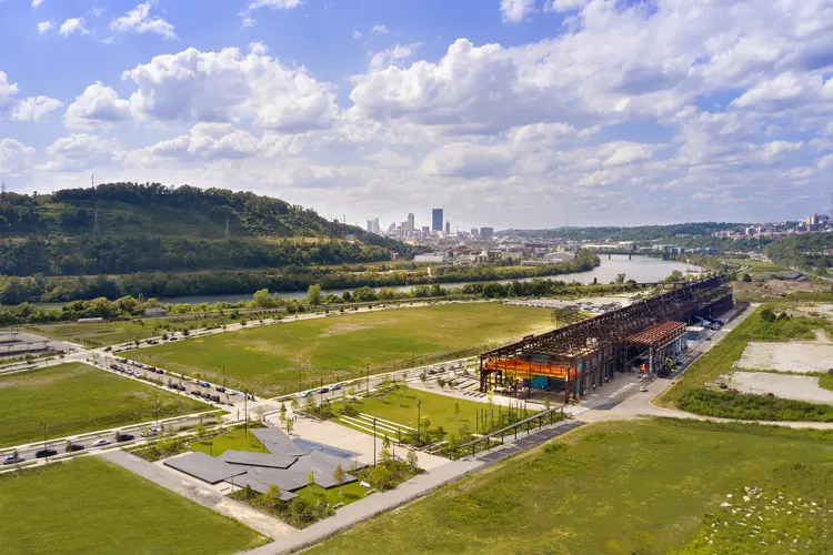 aerial view of Mill 19 in foreground with Pittsburgh, hills and sky in background